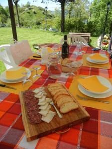 a wooden cutting board with cheese and bread on a table at Terra Del Bosco Agriturismo in Sesta Godano