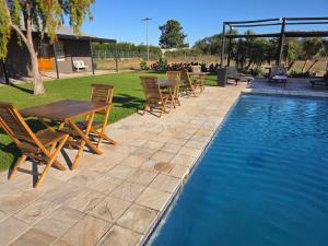 a group of tables and chairs next to a swimming pool at Lemon 3 Lodge Guesthouse in Kirkwood