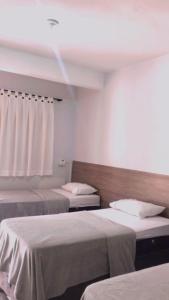 a hotel room with two beds and a window at Hotel El Shaday in Nazário +12 photos