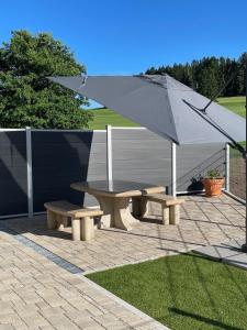 Una mesa de picnic y una sombrilla en un patio. en GreenHolidays, en Wellendingen