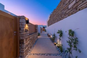 a stone wall and a pathway between two buildings at Ios Art Suites in Ios Chora