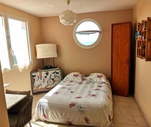 a bedroom with a bed and a round window at Horizon Mer in Le Gosier +8 photos