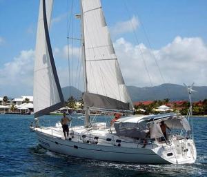 ein weißes Segelboot mit zwei Männern darauf im Wasser in der Unterkunft 20 Minutes de Montréal, 1 chambre et 2 lits pour maximum 4 personnes in Pointe-Calumet