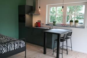 a kitchen with a black table and a counter top at Boerderij Lodge De Haarakker in Langeveen