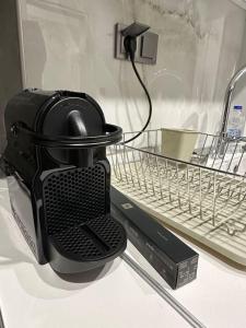 Un electrodoméstico negro colocado encima de un lavavajillas. en A living skg 2 Quiet Luxury, en Tesalónica