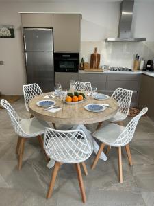 Una cocina con una mesa y sillas con un bol de naranjas. en Casa La Pita, en El Pozo de los Frailes