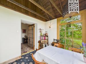 a bedroom with a large window and a table at Priestrig Cottage in Hawick