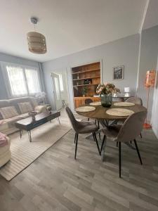 a living room with a table and chairs and a couch at Appartement à 2 pas du centre, 2 chambres, parking in Aurillac