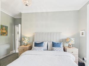 a bedroom with a large bed with blue pillows at Duke Street Suite in Hawick