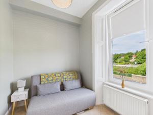 a couch in a room with a window at Duke Street Suite in Hawick
