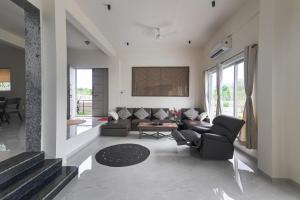 a living room with a couch and chairs at River bloom escape in Karjat
