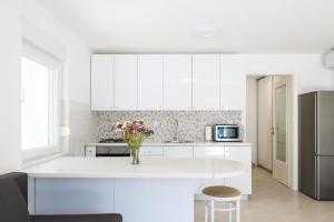 a kitchen with white cabinets and a white counter top at Villa Mir Punta Radman in Petrcane