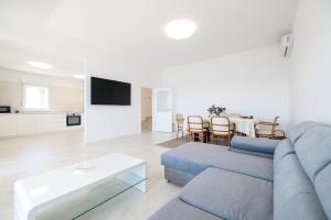 a living room with a blue couch and a table at Villa Mir Punta Radman in Petrcane