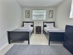 two twin beds in a room with a table at Conant Gray in Jacksonville
