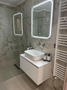 a white bathroom with a sink and a mirror at A living skg 1 Quiet Luxury in Thessaloniki