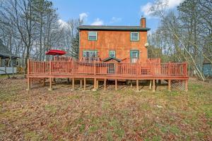 a large wooden deck in front of a house at Pocono Chalet Towamensing with Hot Tub Lake and Pool in Albrightsville