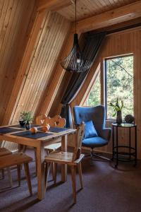 a dining room with a table and a blue chair at Leśna Sielanka domek z jacuzzi w lesie pod Górą Szczebel RELAX I SPORT in Lubień