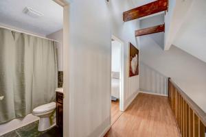 a white bathroom with a toilet and a staircase at Pocono Chalet Towamensing with Hot Tub Lake and Pool in Albrightsville +60 photos