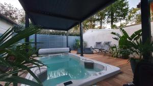 富拉Le Noroit Chambres d'Hôtes的植物庭院中间的游泳池