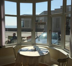 a room with a table and a window with a car at Spaview in Bridlington