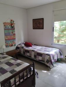 a bedroom with two beds and a window at Guindo Cariló in Carilo