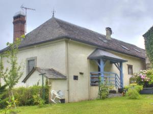 une maison blanche avec un toit et une cour gazonnée dans l'établissement Au Gré des Saisons - 3 chambres, à Gère-Belesten