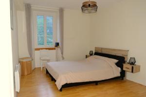 une chambre avec un grand lit et une fenêtre dans l'établissement Au Gré des Saisons - 3 chambres, à Gère-Belesten 12 autres photos