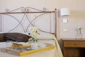 a tray with food and drinks on a bed at Fontana Murata Resort & spa in Borgo Regalmici +20 photos