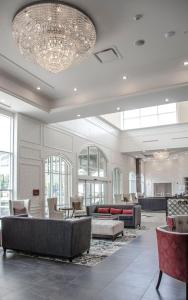a lobby with couches and chairs and a chandelier at The Delavan Hotel in Buffalo