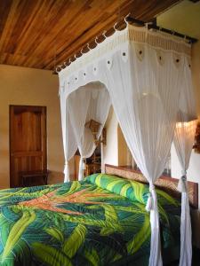 a bedroom with a bed with a canopy at Lost Iguana Resort and Spa in Fortuna