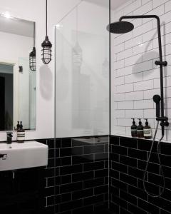 a black and white bathroom with a shower and a sink at The Black Ace Yamba in Yamba +44 photos