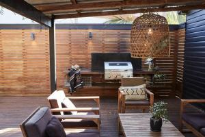 a patio with a table and chairs and a television at The Black Ace Yamba in Yamba