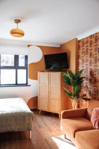 a living room with a couch and a tv at 70s Hideaway Guest Studio for 2 I Private I Self Contained I Near Cardiff in Cardiff