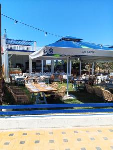 a patio with tables and chairs and an umbrella at Sea view house in Sozopoli