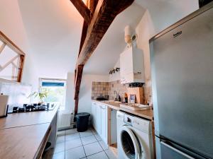a kitchen with a refrigerator and a dishwasher at Appartement Cozy - Dernier Étage - Parking Auxerre in Auxerre