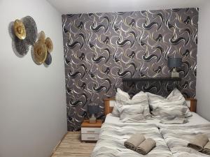 a bedroom with a large bed and a wall at G&G Apartman in Balatonszepezd