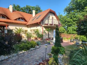 a house with a balcony in a garden at G&G Apartman in Balatonszepezd