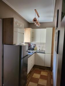 a kitchen with white cabinets and a refrigerator at G&G Apartman in Balatonszepezd