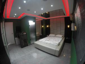 a bedroom with a bed in a room with red lighting at Motel Tenda in Maringá +1 photo