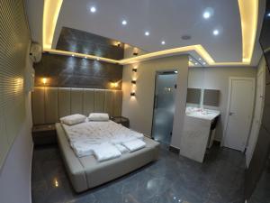 a bedroom with a bed and a bathroom with a sink at Motel Tenda in Maringá