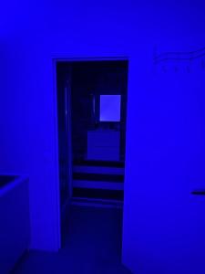 a dark room with a hallway with a blue light at DouceNuits in Le Blanc-Mesnil