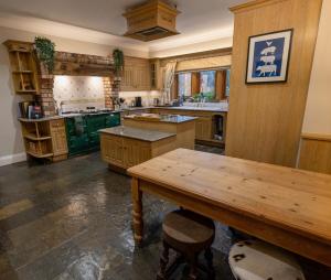 a large kitchen with wooden cabinets and a wooden table at The Grange, Brockhall  +9 photos