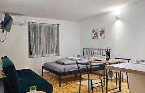 a small room with a bed and a table and chairs at Apartman SOKAK in Satnica +57 photos