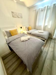 two beds sitting next to each other in a bedroom at Cosy apartment in town centre in Finedon