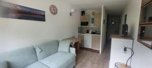 Una sala de estar con un sofá azul y una cocina. en studio plein sud vue Mont Blanc CHAMONIX, en Chamonix-Mont-Blanc 8 fotos más