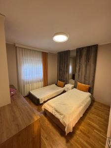 Una habitación de hotel con dos camas y una ventana. en Garden Villa in Peja, en Peje 4 fotos más