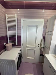 lavadero con puerta blanca y lavadora en Garden Villa in Peja, en Peje