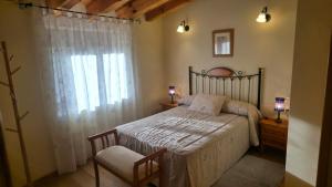 a bedroom with a bed and a window and a chair at Casa Rural La Celestina in Navalmoro