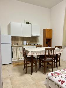 a kitchen with a table and chairs and white cabinets at casa vacanza in Laterza