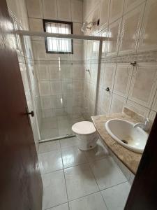 a bathroom with a shower and a toilet and a sink at Casa com Piscina em Itaipuaçu in Maricá +8 photos